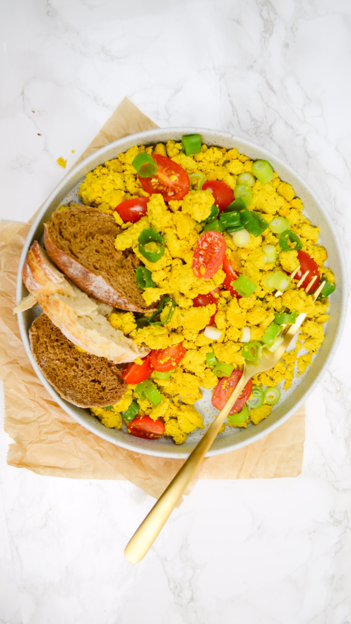 plate on a table with tofu scramble bread and mixed vegetables